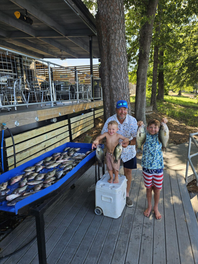 Grandpa showing fish caught on Toledo Bend with two grandsons 