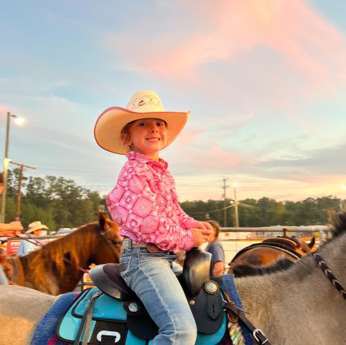 Young girl on horse at rodeo 