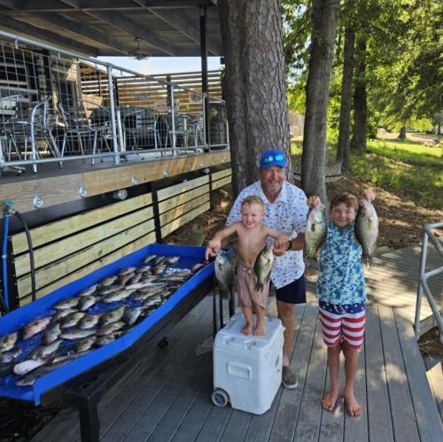 Grandpa showing fish caught on Toledo Bend with two grandsons 